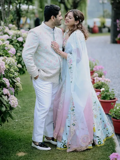 A classic couple portrait surrounded by beautiful flowers, capturing the romance of their Nainital engagement.