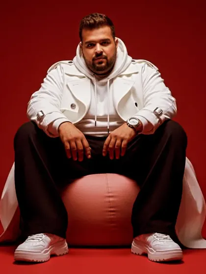 A modern, stylish look from a recent photoshoot. The white trench coat and bold red background make a strong statement.