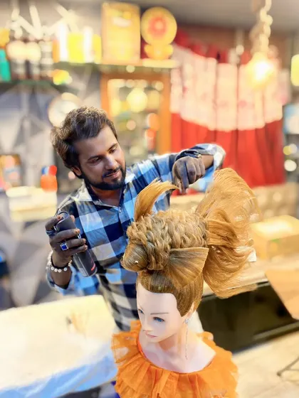 Here I am adding the final touches to the fish hairstyle. My classes are hands-on, and I personally guide students through complex techniques like this, ensuring they understand every detail.