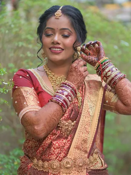 Another beautiful shot of the bride getting ready, showing the details of her saree, blouse, and traditional waist belt (vaddanam).