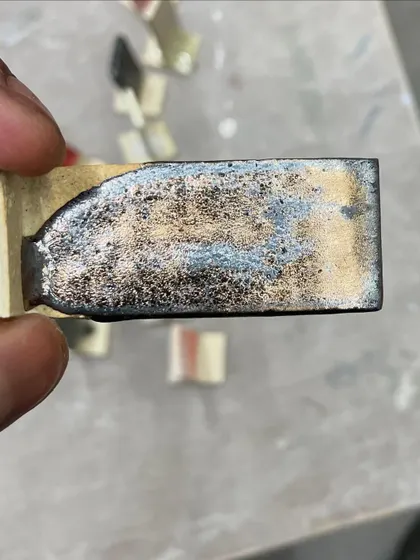 Another glaze test, this time resulting in a metallic, cratered surface. The chemistry of ceramics is full of wonderful surprises.
