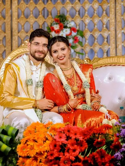 A beautiful portrait of the couple on their wedding stage, surrounded by a vibrant arrangement of colorful flowers.