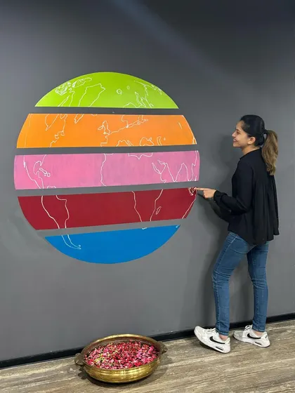 Pointing to my next travel destination on the globe mural. This piece was all about global reach and connection.
