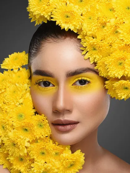 For editorial and creative shoots, I love incorporating natural elements. In this beauty portrait, we built the concept around these vibrant yellow flowers, matching them with bold yellow eyeshadow for a cohesive and visually arresting image. This is a great example of a conceptual beauty shoot.