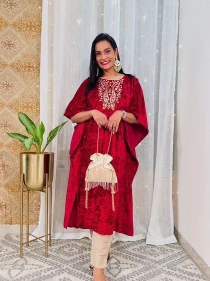 This red velvet kaftan with gold embroidery is a luxurious and festive piece. It's perfect for a winter wedding or a special occasion.