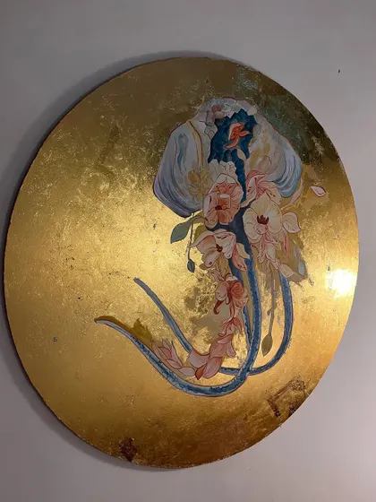 The finished jellyfish artwork, a circular canvas where a translucent sea creature adorned with flowers floats on a sea of gold leaf. This piece is designed to be a luxurious, imaginative focal point.