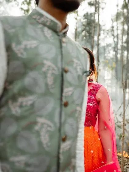 A creative shot of a couple in a forest setting, with a line of fire in the foreground, creating a dramatic and powerful image.