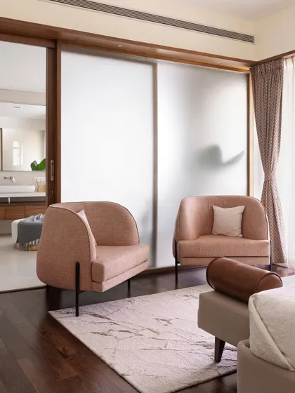 This view of the primary room in 'A Walk in the Clouds' shows the cozy seating area with two blush armchairs, creating a perfect spot for conversation or relaxation.