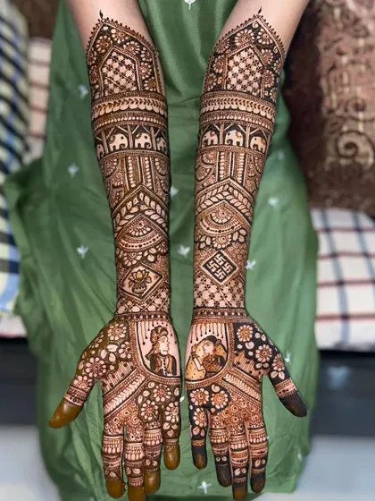 This custom bridal design features couple portraits surrounded by floral patterns. The arms are adorned with traditional elephant motifs and swastikas.