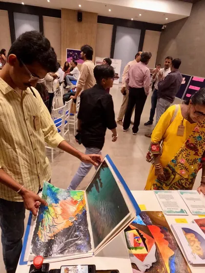 A visitor at my Mumbai exhibition looking through a portfolio of my smaller works. It's always a joy to see someone take their time with my art, discovering the different stories and styles within my collection.