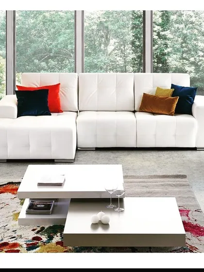 An all-white L-shaped sofa creates a bright and airy feel in any living room. This piece features a modern, low-profile design with clean lines and tufted seating. It serves as a perfect blank canvas, allowing you to add color and personality with cushions and throws.