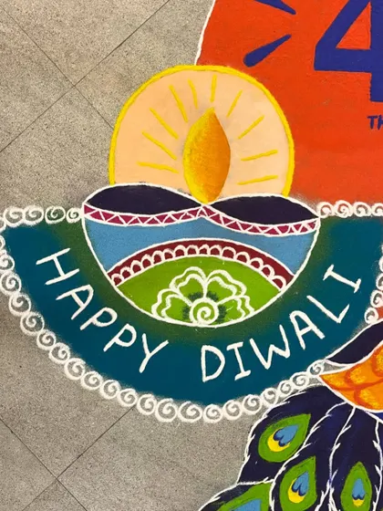 Detail shot of the "Happy Diwali" message and diya from a branded floor art piece. Even with custom text and logos, I ensure the traditional festive feeling is central to the design.