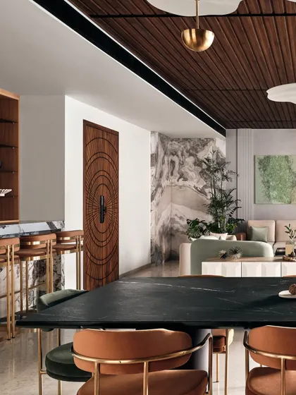 This shot highlights the rich details of the home, including a custom carved wooden door, a marble-clad bar area, and a statement marble wall in the background.