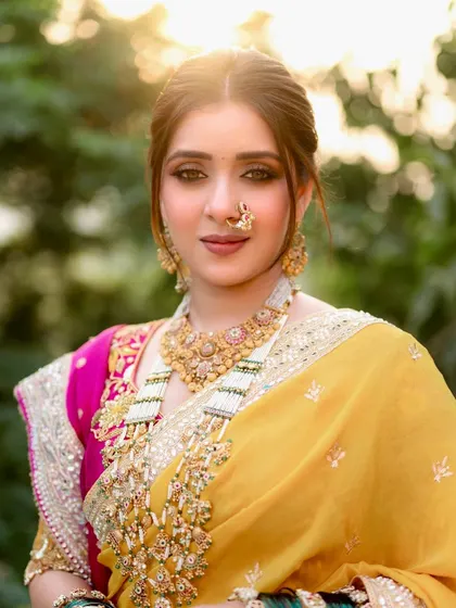 The golden hour light beautifully illuminates her radiant skin. This close-up captures the soft glam makeup, with a focus on a flawless base and subtly defined eyes.