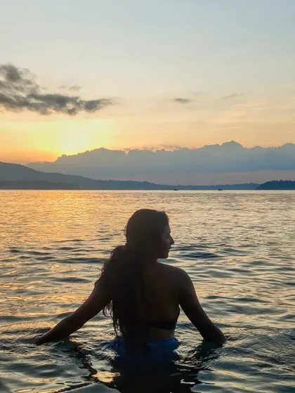 A serene silhouette in the water during an Andaman sunset. This beautiful shot captures the essence of being an island girl and is perfect for swimwear or travel campaigns.