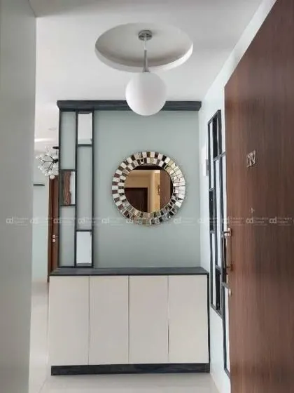The entrance view, featuring a stylish shoe rack with a decorative mirror and a modern pendant light, setting an eclectic and welcoming tone.
