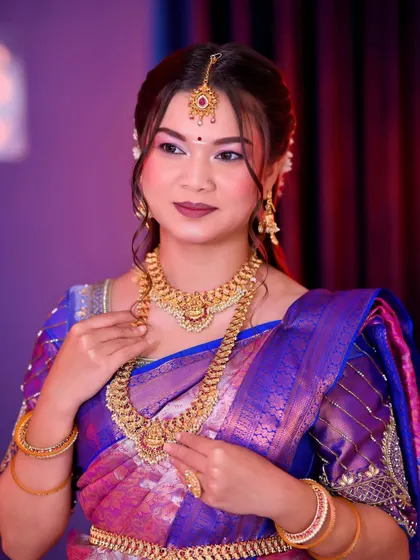 A full-length view of the South Indian bride in her stunning purple and blue Kanjeevaram saree. The entire look, from makeup to attire, is a perfect blend of tradition and grace.