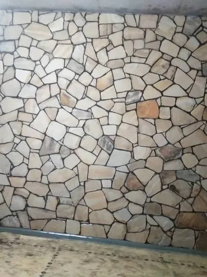 A full interior wall covered in light-colored, random-pattern stone cladding. This creates a stunning, rustic feature wall.