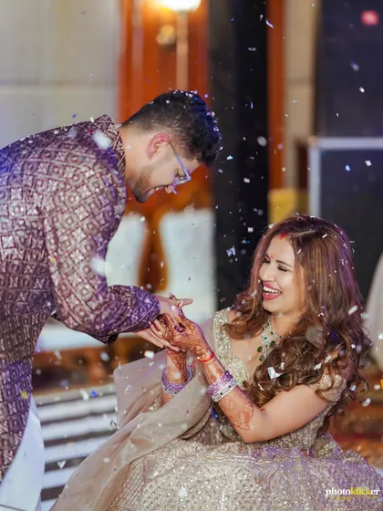 The couple shares a laugh amidst a shower of confetti during their Sangeet. These dynamic shots perfectly capture the festive atmosphere.