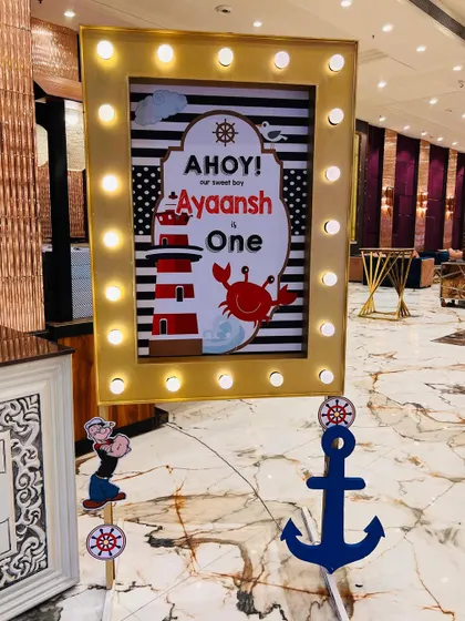 A personalized welcome sign for a nautical-themed first birthday, featuring an "Ahoy! Ayaansh is One" message with Popeye and anchor props.