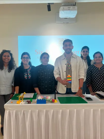 A group photo with the workshop facilitator and some of the amazing LEGO creations. This image captures the sense of accomplishment and shared learning that defines my professional development sessions.