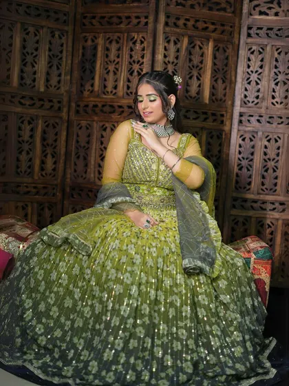 A final seated shot of the green and yellow floral lehenga, a perfect choice for a fun and festive occasion.