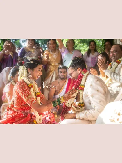 A joyful moment from a traditional wedding ceremony. The bride's makeup is designed to be radiant and long-lasting through all the rituals and celebrations.