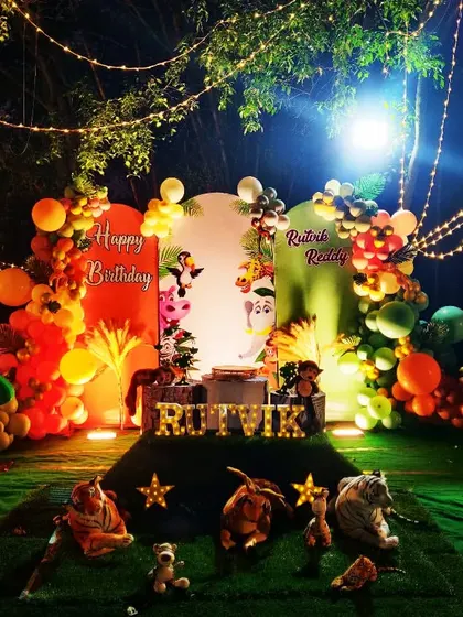An enchanting nighttime jungle theme for Ritvik Reddy. I used string lights to create a magical, starry sky effect over the green turf and animal-filled scene.