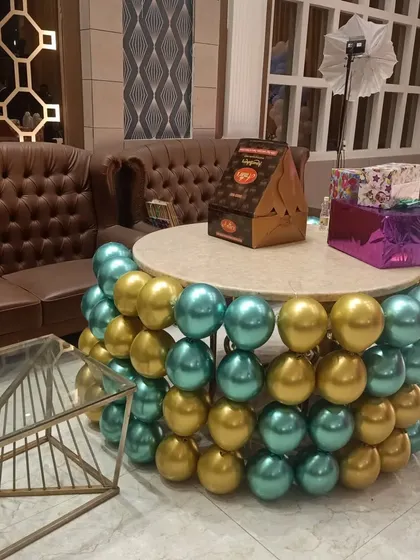 A creative cake table decorated with balloons. This is a unique add-on that makes the cake-cutting ceremony even more special.