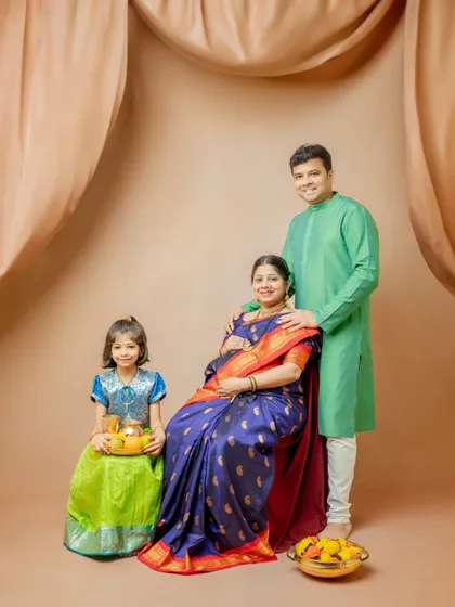 A complete family portrait celebrating the upcoming arrival. The older sister joins her parents, all dressed in beautiful traditional clothing, creating a heartwarming image of a growing family.