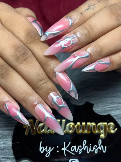 For those who love a bold and edgy look, I create designs like this. This set features long stiletto extensions with a pink base and a raised, metallic silver chrome design for a futuristic 3D effect.