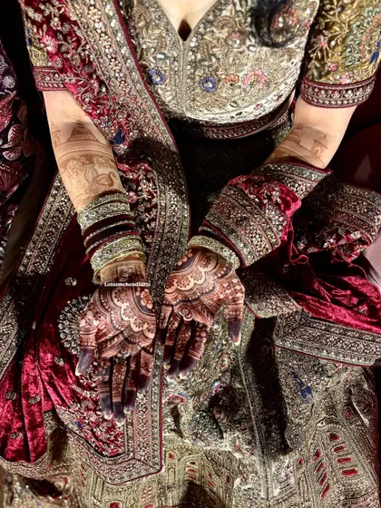 A fresh, dark stain on mehendi night, perfectly complementing the bride's heavily embroidered velvet lehenga.