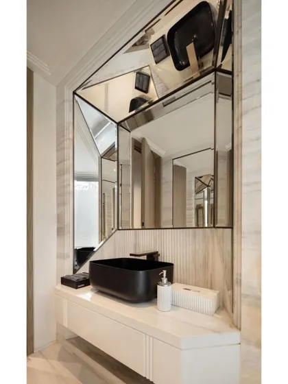 The powder room in the Delhi office is articulated with clean, crisp lines. A geometric mirror arrangement and ribbed natural stone backsplash create a modern and expressive design statement.