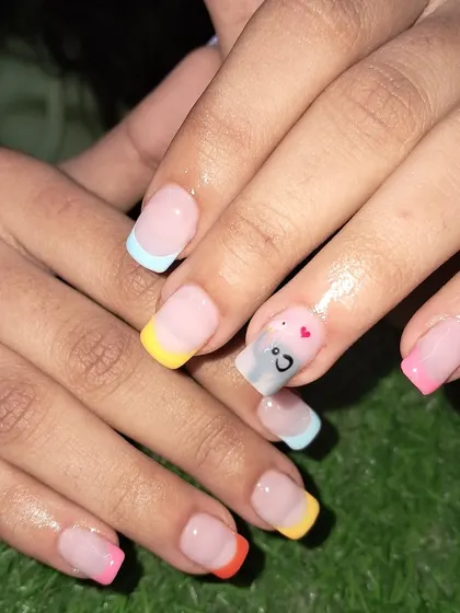 A fun, multi-colored French manicure perfect for summer, with a cute smiley face accent nail.