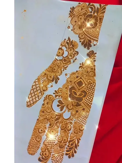 A finished sider henna design on paper, sparkling with glitter. This shows the complete composition, with a mix of geometric and floral patterns creating a balanced look.