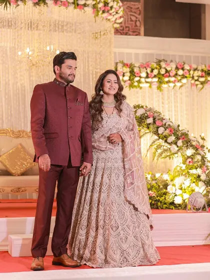 A beautiful couple poses on a stage we designed, featuring a backdrop of cascading lights and floral arches. Our decor provides the perfect setting for capturing timeless wedding portraits.