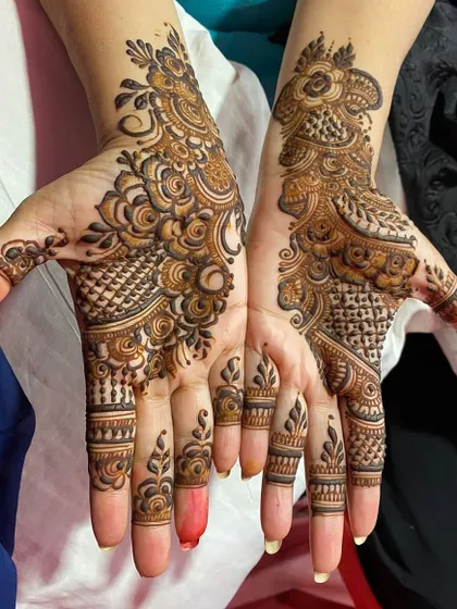 A detailed design created with a fellow mehendi artist. It features a mix of checks, swirls, and leafy patterns for a full and festive look.