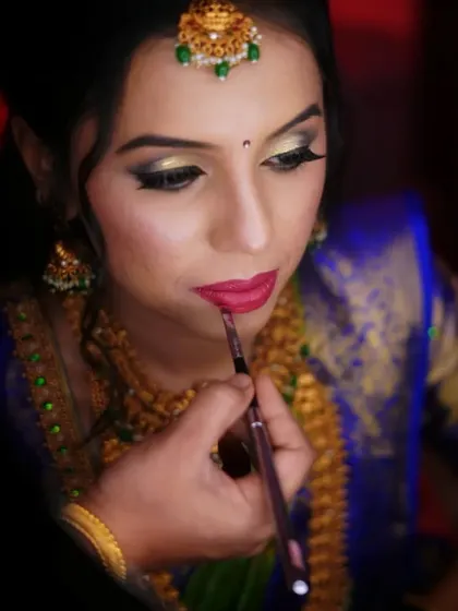 A behind the scenes shot of me giving the final touches to the bride's lips. These professional photos from Chaithra show the care and precision that goes into every step of the makeup application.