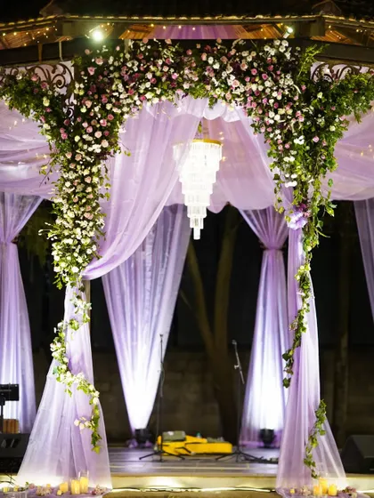 A dreamy combination of lavender drapes and a sparkling crystal chandelier. This decor element creates a soft, romantic, and utterly magical ambiance for an evening celebration.