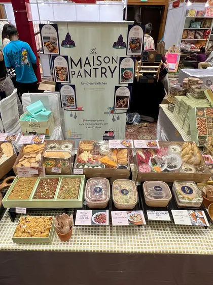 My stall at the Jalsa Exhibition, fully stocked and ready for a busy day. The display features my signature dips box, salads, desserts, and a variety of mithai.