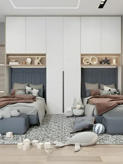 We designed this shared bedroom for two children with a focus on symmetry and personal space. Each bed has its own headboard niche with a reading light, and the space is unified by a neutral color palette and matching wardrobes.