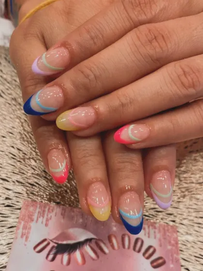 A fun and colorful take on the French manicure. Each almond-shaped nail features a different pastel or bright color at the tip, with delicate curved lines for a modern touch.