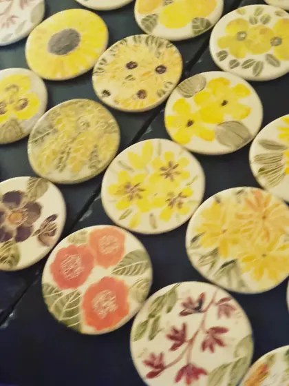 A close up of some of my yellow and red themed floral coasters. From sunflowers to poppies, each one is a small, detailed painting.