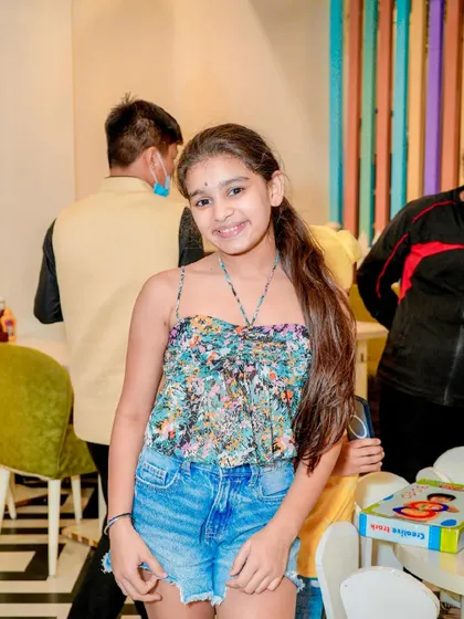 A young guest smiles for the camera while enjoying the party.