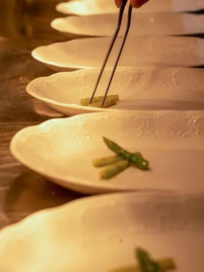 A row of plates being meticulously prepared for service.