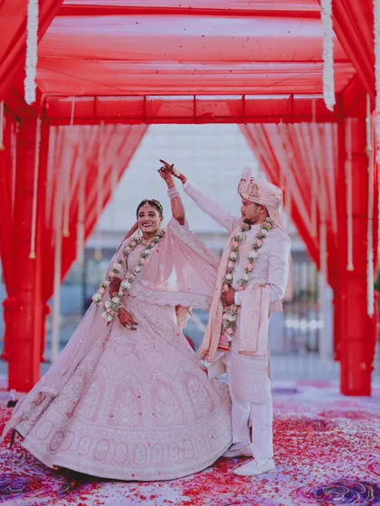 A joyful dance under a red canopy, capturing the couple's happiness during their wedding ceremony.