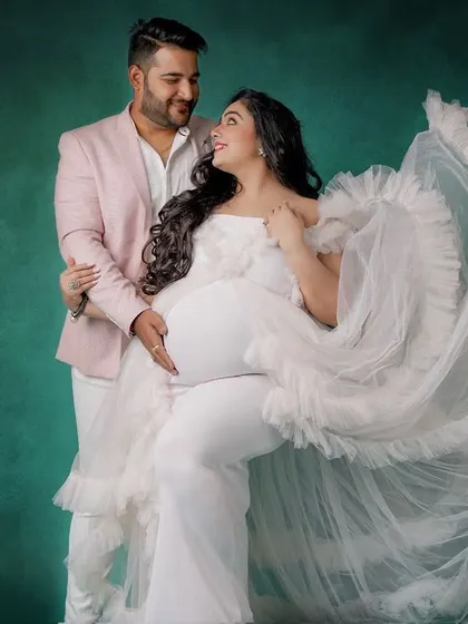 Creating a coordinated look for you and your partner is one of my favorite things to do. Here, my client wears a stunning white ruffled gown, perfectly complemented by a soft pink blazer for her partner, making their studio maternity session truly special.
