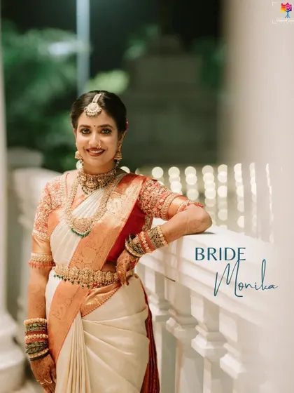 A smiling portrait of the bride, Monika, on her wedding night. Her classic white and red saree and joyful expression are beautifully captured in the evening light.