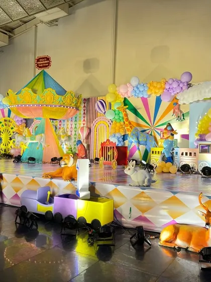 A side view of the large carnival stage, showing the depth and variety of props used, from a school bus to a circus train.
