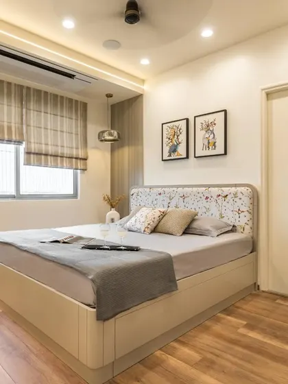 A minimalist beige bedroom design featuring a custom-made bed with under-storage and a beautiful floral fabric headboard.
